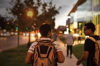 two male students walking by street